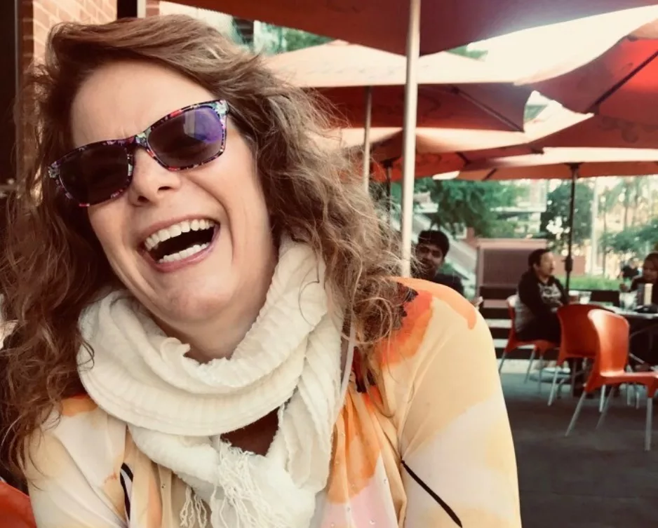 Avallo Owner Julie Hamilton laughing on vacation at an outdoor cafe.